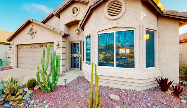 Southwestern home with colorful patio, sparkling pool, grill & dart board